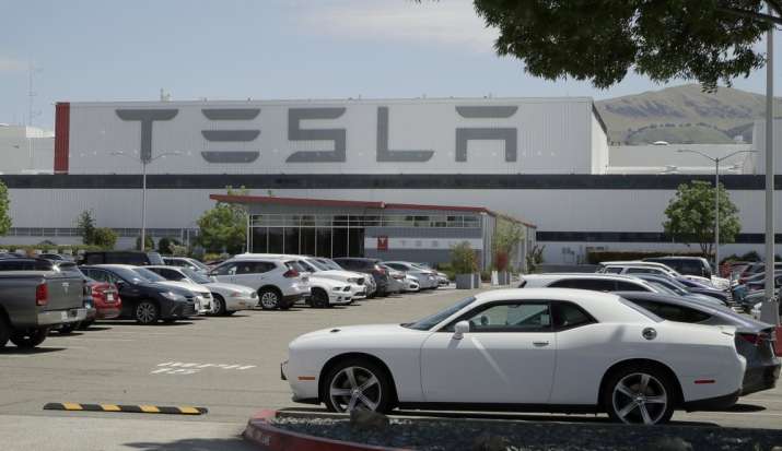 Vehicles are seen parked at the Tesla car plant Monday, May 11, 2020, in Fremont, Calif. The parking