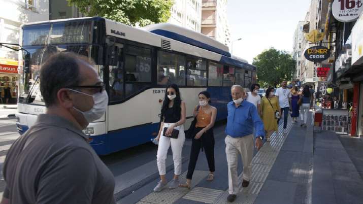 People wearing face masks and keeping social distance to