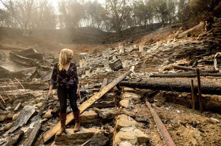 Pam, who declined to give a last name, examines the remains of her partner's Vacaville, Calif., home