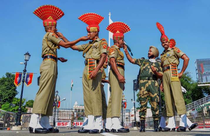 Border Security Force (BSF) soldiers offer sweets to each other during the 74th Independence Day cel