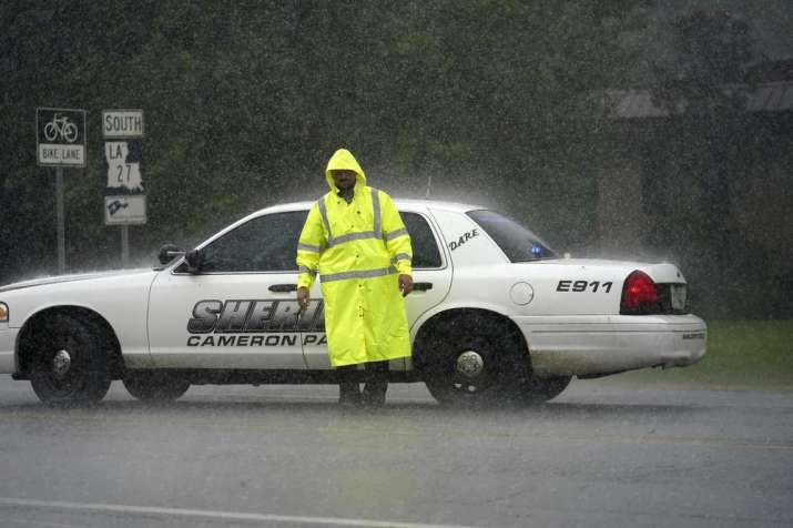 India Tv - A Cameron Parish Sheriff's deputy mans a roadblock in the rain on LA 27 as residents evacuate Camero
