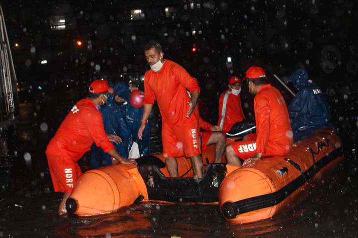 India Tv - Mumbai: National Disaster Response Force (NDRF) personnel rescue passengers from a local train stranded between Masjid Bunder and Byculla stations on the Central line, during heavy rain, in Mumbai, Wednesday, Aug. 5, 2020. 