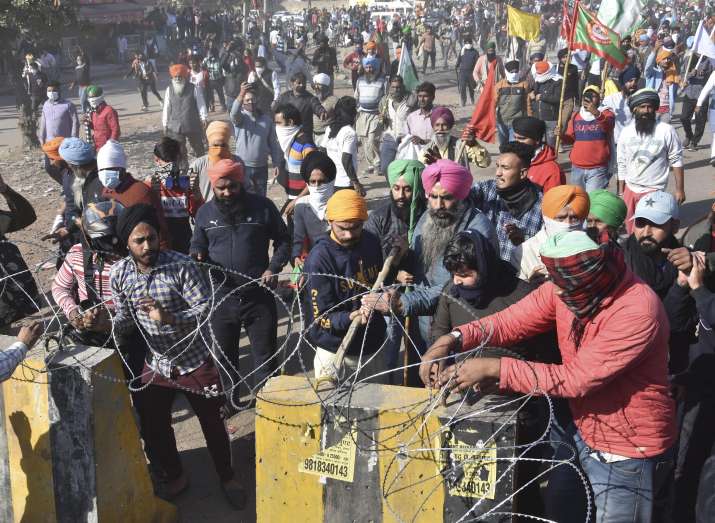 India Tv - New Delhi: Farmers attempt to cut concertina wire fencing at a police barricade as they march towards Delhi during Delhi Chalo protest march against the new farm laws, at Singhu border in New Delhi, Friday, Nov. 27, 2020.