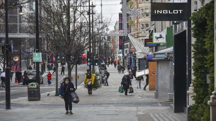 A woman wears a face mask as she walks in a near empty