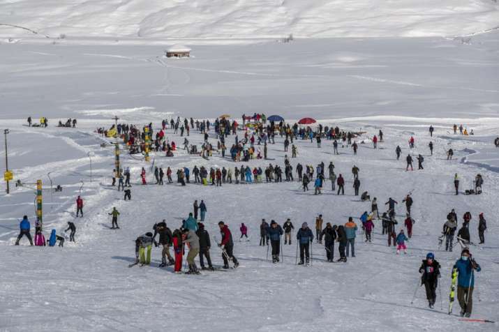 Indian tourists and locals ski on a slope in Gulmarg,