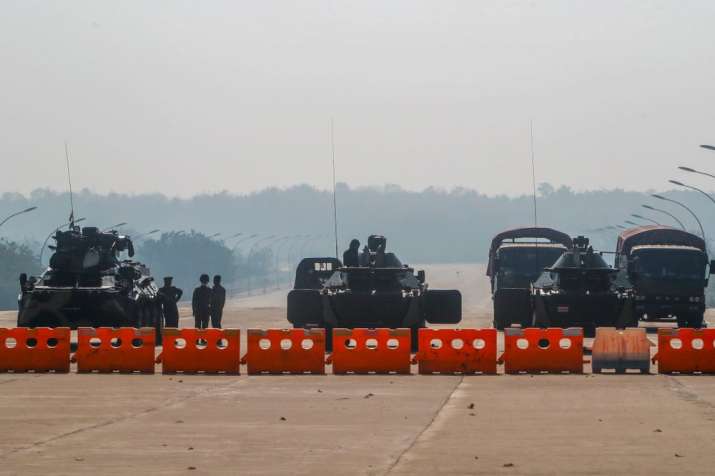 Myanmar's military stand guard at a checkpoint manned with an armored vehicles blocking a road leadi