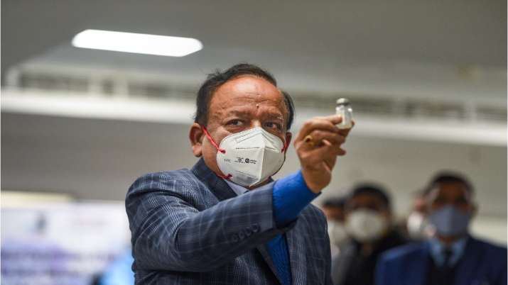 Union Health Minister Harsh Vardhan displays a Covishield