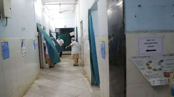 Health workers talk inside a vaccination centre.