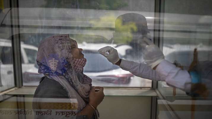 A health worker takes a swab sample to test for COVID-19 at