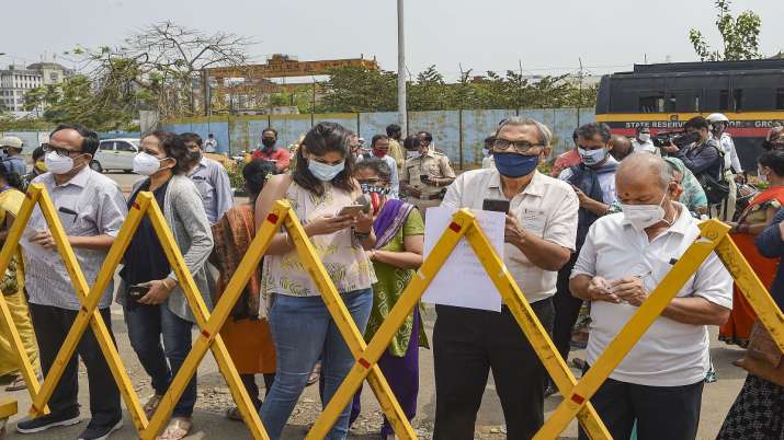 People stand behind a barrier outside a Covid-19