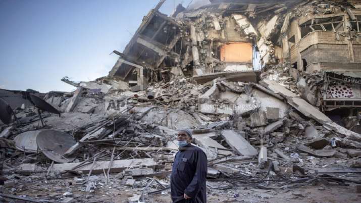 A Palestinian man looks at the destruction of a building