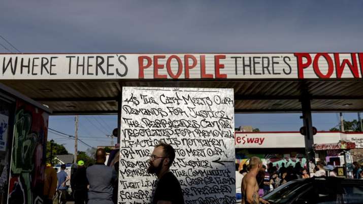A crowd gathers near the gas station at George Floyd