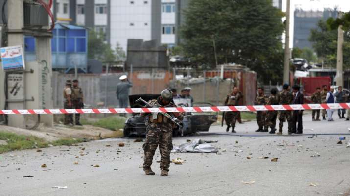 Security personnel inspect a damaged vehicle that was