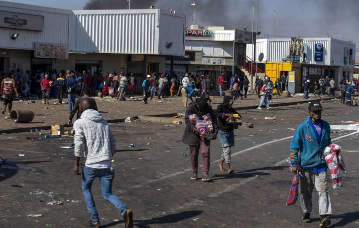 India Tv - People carrying groceries loot at the Letsoho shopping center in Katalhong, east of Johannesburg, South Africa.