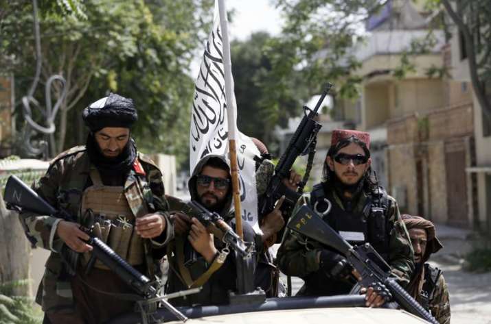 Taliban fighters display their flag on patrol in Kabul,