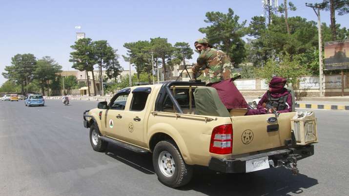 Taliban fighters sitting in the back of a vehicle in the city