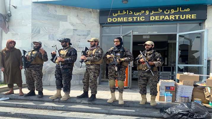 Taliban fighters stand guard inside the Hamid Karzai