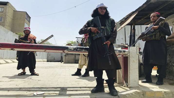 Taliban fighters stand guard at a checkpoint near the US