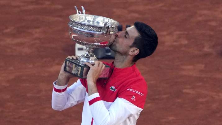 India Tv - In this June 13, 2021, file photo, Serbia's Novak Djokovic kisses the trophy after defeating Stefanos Tsitsipas