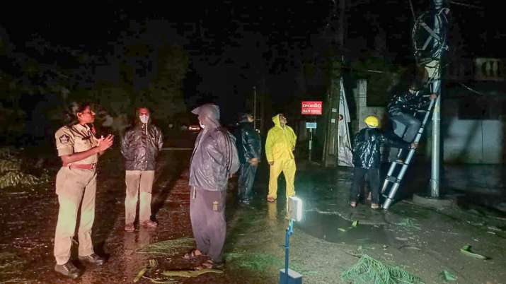 Police personnel and local people at a site after a tree fell