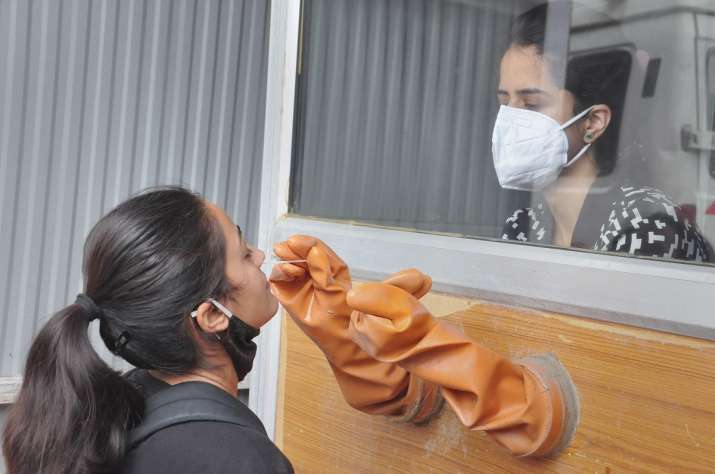 A health worker takes a nasal sample for COVID-19 test