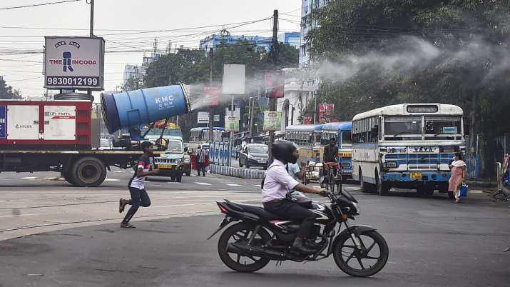 Municipal corporation workers use a mist cannon to sanitize