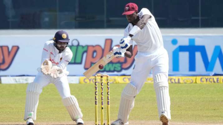 West Indies' batsman Jason Holder plays a shot as Sri Lankan wicketkeeper Dinesh Chandimal watches d