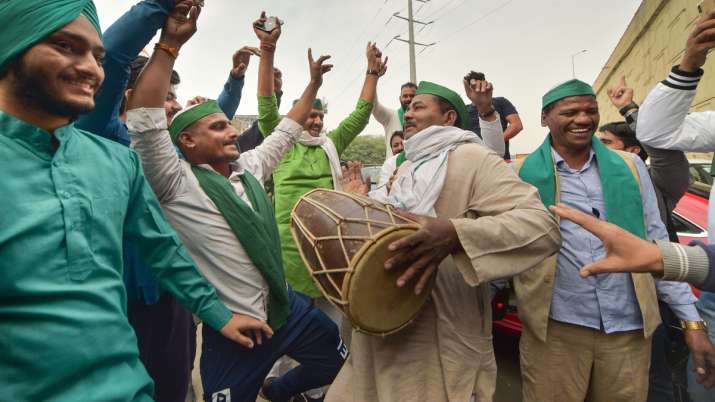Farmers dance as they celebrate after PM Narendra Modi