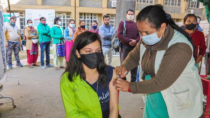 A health worker inoculates a dose of Covid-19 vaccine to a