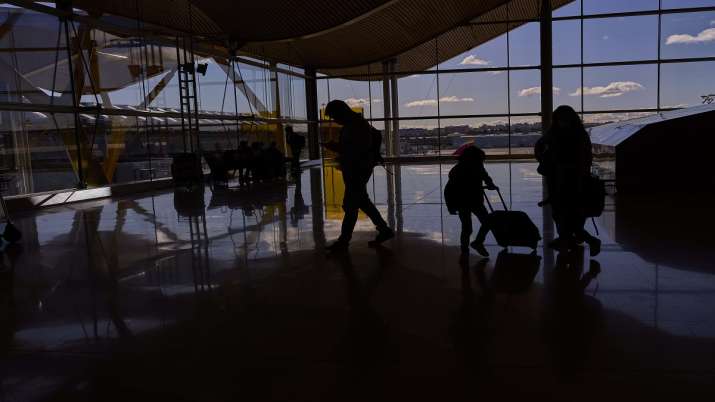 Passengers walk at an international airport as new Covid