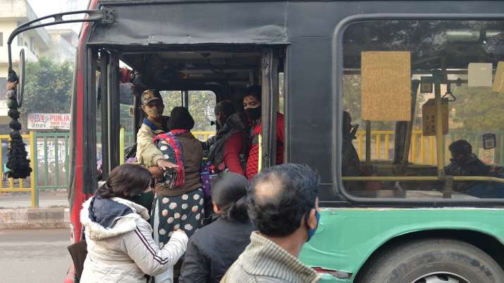 India Tv -  A Civil Defence Staff stops passengers to board a bus after fifty percent seats were occupied, in New Delhi, Wednesday, Dec. 29, 2021.