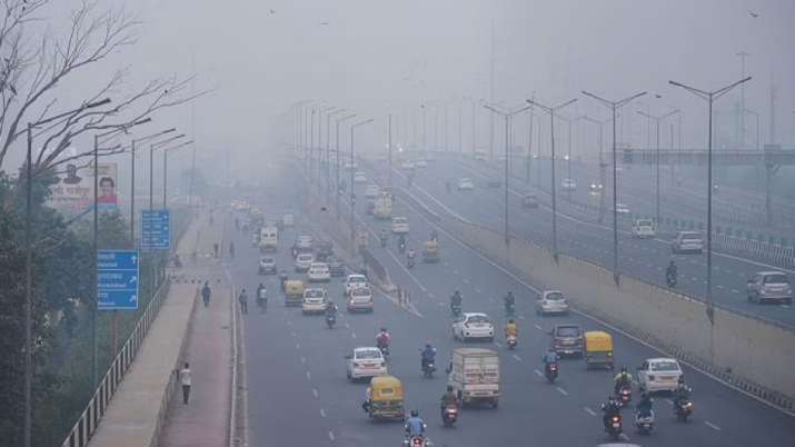 Vehicles ply amid an atmosphere shrouded in smog in New