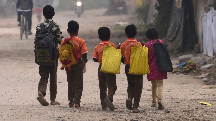 School children walk along a road, amid smog in New Delhi,