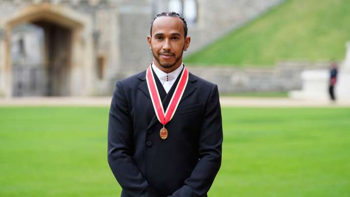 Lewis Hamilton poses with knighthood medal
