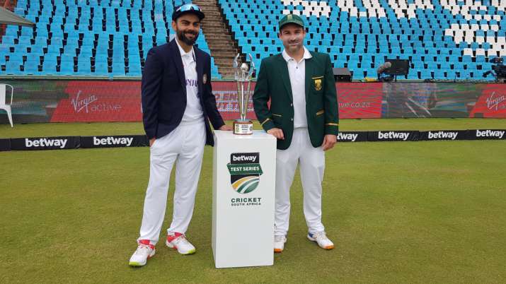 Virat Kohli and Dean Elgar pose in front of the trophy