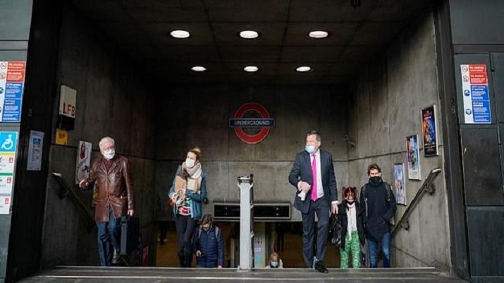 People wear face masks as they leave the Westminster Underground