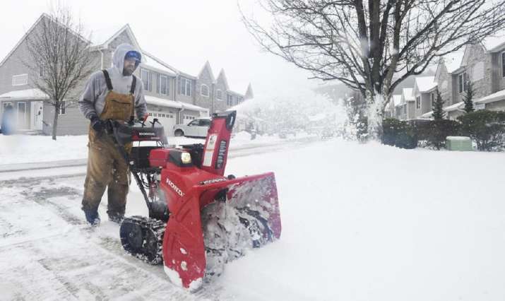 Joe Miscavage uses a snow blower to clear a driveway at