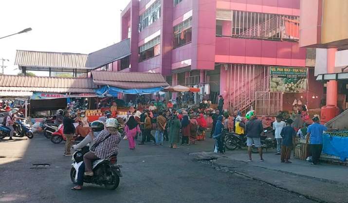 People wait outside after evacuating a market following an