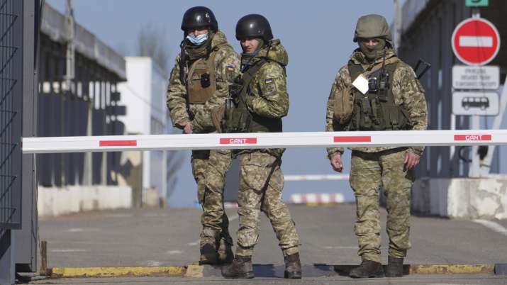 Ukrainian border guards stand at a checkpoint from