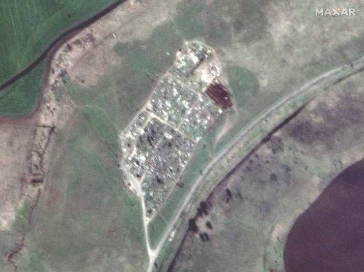India Tv - This satellite image provided by Maxar Technologies shows an expansion of graves at a cemetery near Vynohradne, approximately 12 kilometers east of Mariupol  