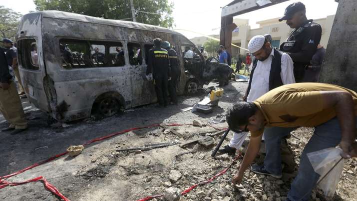 Pakistani investigators gather evidence at the site of