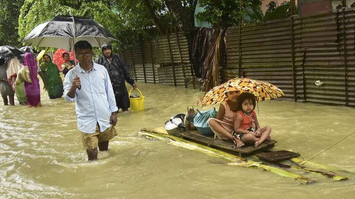 India Tv - People use a banana raft to move to a safe place at a flood-hit village in Nalbari district of Assam