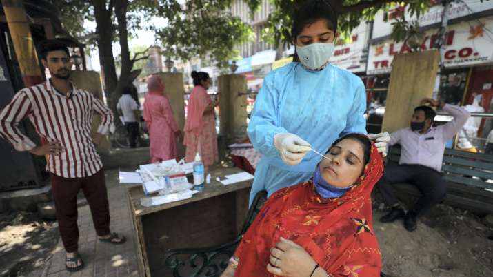 A health worker collects a swab sample from a woman
