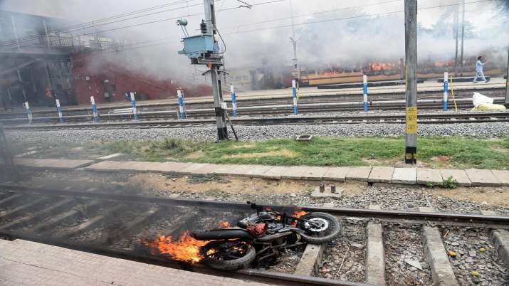 India Tv - A motorcycle in flames at a railway track after a mob vadalised Farakka Express train and railway properties in protest against the Agnipath scheme, at Danapur Station near Patna, Friday, June 17, 2022
