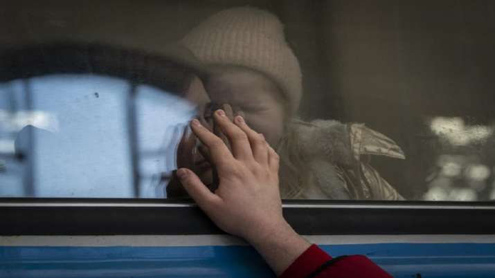 India Tv - Displaced Ukrainians on a train bound for Poland bid farewell in Lviv, western Ukraine, Tuesday, March 22, 2022.