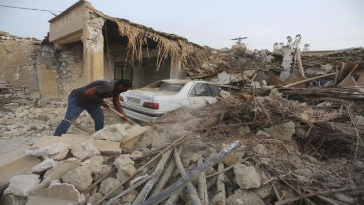 A man cleans up the rubble after an earthquake at Sayeh