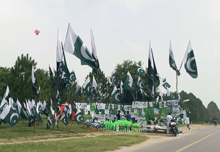 India Tv - Pakistani street vendor sells national flags, badges and masks ahead of Pakistan Independence Day celebrations, in Islamabad, Pakistan. 