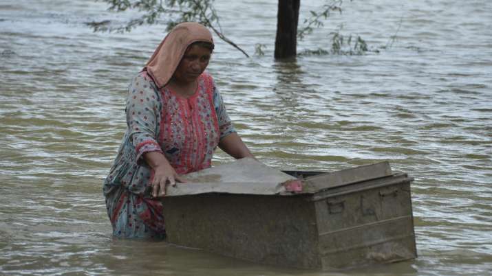 India Tv - A woman uses a trunk to salvage usable items from her flood-hit home in Jaffarabad, a district of Pakistan's southwestern Baluchistan province
