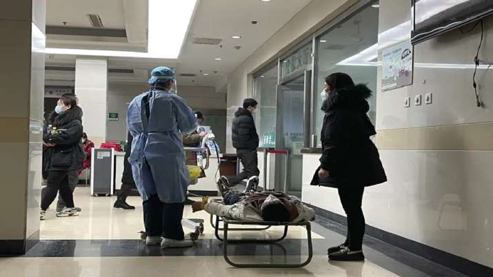 India Tv - A hospital worker prepares to perform tests after placing electrodes to the chest of a man sprawled out on a stretcher outside the emergency ward at the Langfang No. 4 People's Hospital in Bazhou city in northern China's Hebei province.