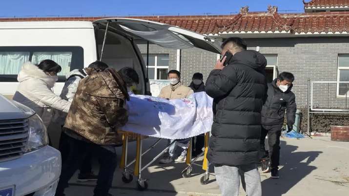 India Tv - Liang from Beijing, center looks on as his 82-year-old grandmother is brought in a casket to the Gaobeidian Funeral Home in northern China's Hebei province.